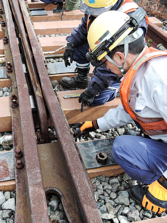 線路のポイント部分を点検する作業員